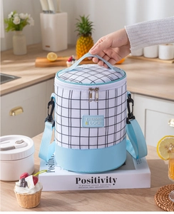 Detail of insulated cylinder lunch bag with blue strap and waterproof lattice fabric