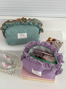 Detailed close-up of quilted plaid cosmetic bags with ruffled edges in green and purple