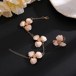 Makroaufnahme von rosa Emaille-Blumenschmuckset mit Armband und Ring in Roségold