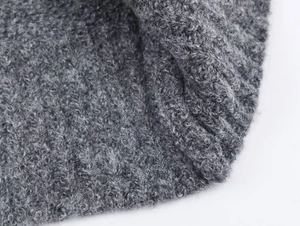 Macro shot of dark grey boucle knit fabric texture with soft plush curly fibers