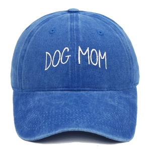Detail of white DOG MOM embroidery on a vintage washed blue cotton baseball cap