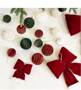 Flat lay of flocked burgundy Christmas balls with velvet bows and green branches