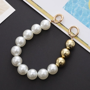 Detail of white large pearls and gold round beads phone chain with spring buckles