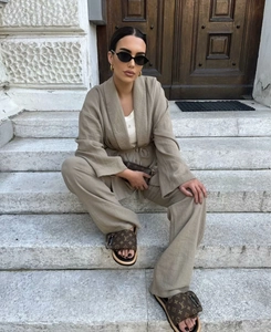 Detail of khaki linen two-piece set featuring wrap tie top and wide leg trousers texture