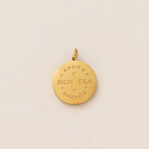 Macro shot of 18K gold plated round biscuit pendant with Rich Tea Biscuits engraving