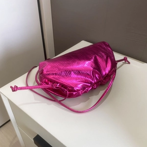 Detail of rose red metallic pleated cloud bag with drawstring and matching shoulder strap