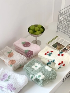 Detailed view of 5 pairs of cartoon coral fleece socks with strawberry and floral patterns