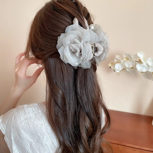 Pince à cheveux rose en tissu élégante portée en demi-queue sur un mannequin