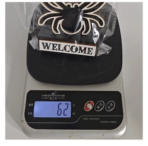 Détail montrant un panneau de bienvenue araignée noire d'Halloween pesé sur une balance