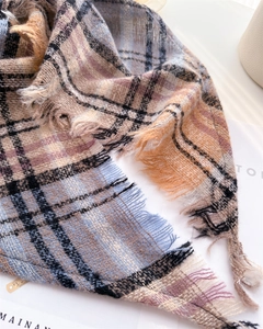Macro shot of soft plaid scarf texture featuring classic tassels and vibrant color weave