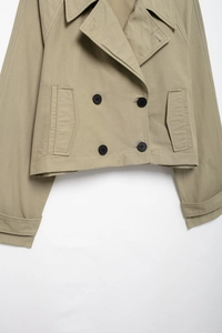 Detail of short double-breasted khaki windbreaker jacket with black buttons and notched lapel
