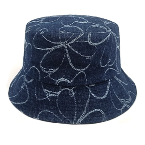 Close-up of white floral line patterns on a deep blue washed denim bucket hat texture