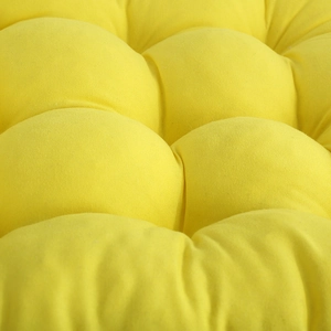 Macro detail of bright yellow quilted chair cushion with thick fabric texture and soft padding