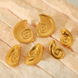 Three pairs of spiral snail-shaped 18K gold titanium steel earrings on a stone base
