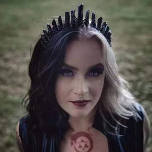 Gothic black crystal moon crown headpiece worn by a model in a mystical natural setting