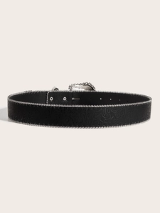 Detail view of a black belt with embossed patterns and silver beaded edges on cream background