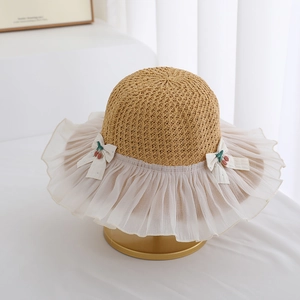 Detailed texture of straw weave and chiffon ruffle brim on a girls princess sun hat