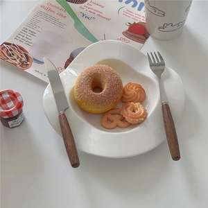 Retro Korean style cutlery set with wooden handles on ceramic plate for table setting