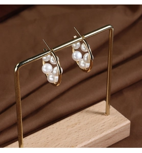Macro shot of gold-plated flower hoop earrings with natural freshwater pearls