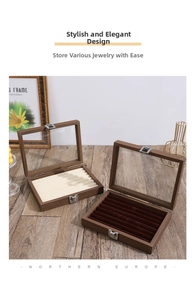 Detail view of walnut wood jewelry box featuring clear glass lid and metal lock closure