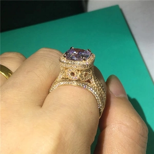 Detail eines Goldrings mit quadratischem lila Stein und funkelnder Zirkonia-Verzierung
