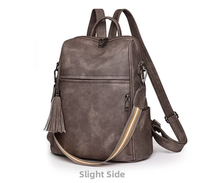 Detail of vintage coffee PU leather backpack with striped strap and tassel charm