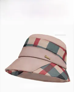 Detail of plaid bucket hat featuring khaki brim and gold LOVE metal emblem