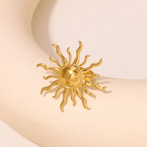 Polished gold sunburst stainless steel ring displayed on a minimalist ceramic art stand