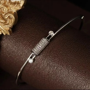 Macro detail of silver-tone knot cuff bracelet featuring micro-pave cubic zirconia stones