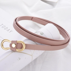 Detailed view of pink PU leather skinny belt with golden U-shaped metal buckle on a prop
