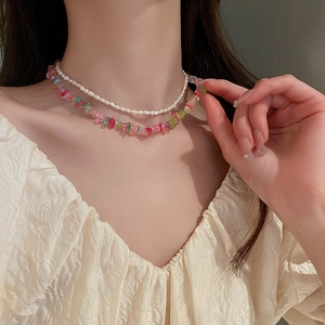 Detail of layered necklace set featuring white pearls and colorful gemstone beads