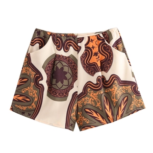 Detail view of lightweight beach shorts with geometric and floral patterns in earthy tones