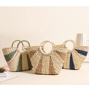 Detailed view of handmade straw tote bags with colorful contrast weaving and round handles