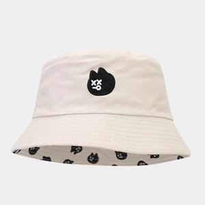 Vue détaillée d'un chapeau bob beige avec écusson chat noir et doublure intérieure imprimée