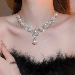 Elegant gold necklace with white pearls and sparkling rhinestones on model neck