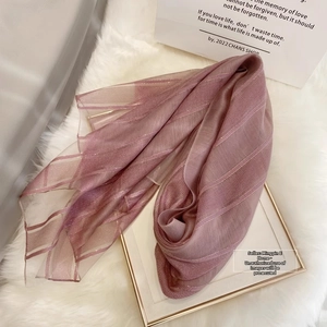 Detail of light pink silk wool scarf featuring horizontal metallic gold stripes texture