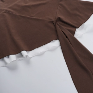 Detail of tiered brown and white halter dress showing layered fabric and tie string closure
