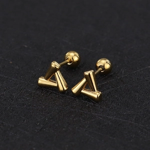 Close-up of golden geometric triangle stud earrings with secure screw-on ball backings
