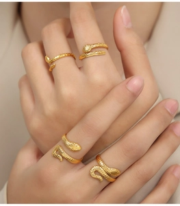 Detailed close-up of gold-plated snake rings with intricate scale textures on hands