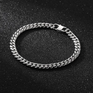 Detail of silver Cuban link chain bracelet with a square buckle on dark texture