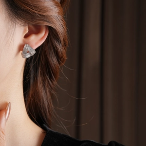 Détail de boucles d'oreilles triangulaires torsadées en argent avec zircons sur un mannequin