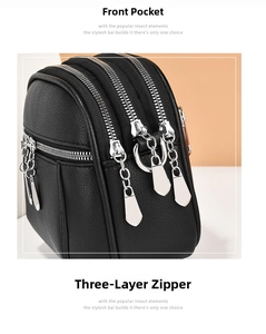 Detail of the black PU leather bag showing three main zippers and a front pocket
