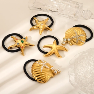 Detail view of 18K gold stainless steel hair ties featuring starfish and seashell charms