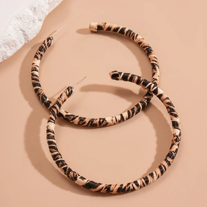Detail of round leopard print hoop earrings with textured fabric wrap and silver needles