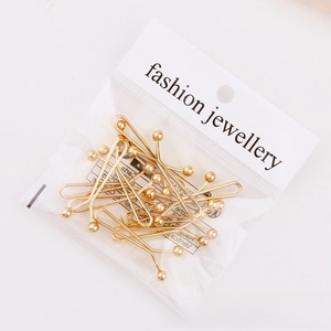 Close-up of golden U-shaped scarf clips in clear packaging with white display cards