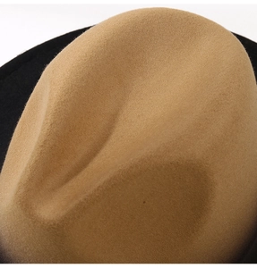Close-up of dual-tone felt fedora hat showing camel crown and black brim textures