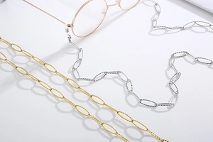 Detailed macro view of gold and silver steel eyewear chains with diamond-cut textures
