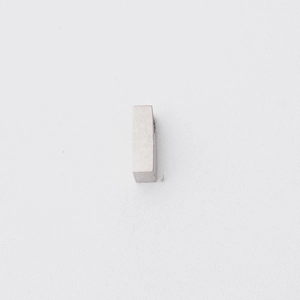 Close-up of polished stainless steel letter bead with small hole for jewelry making