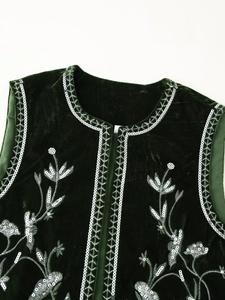Detail of dark green velvet vest with floral embroidery and sequins on the neckline