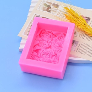 Pink silicone mold for rose-patterned soap and fondant crafts on light blue background